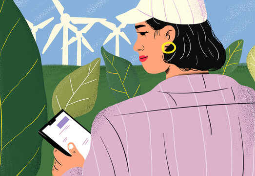 Agronomist with tablet PC at wind turbines in green field