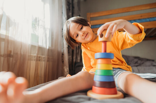 Cute boy playing with educational game at home