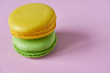 Colorful macaroons on pink background, close-up.