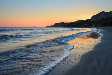 Gentle ocean waves on sandy beach at twilight