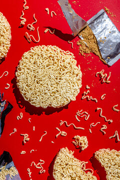 Raw ramen noodles scattered on red table