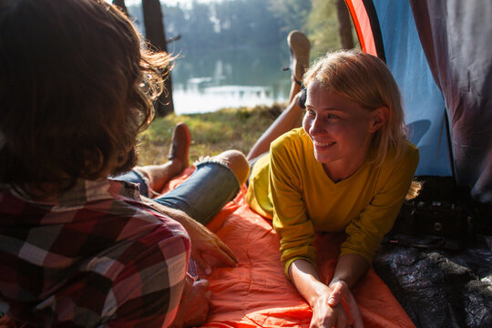 Smiling woman spending leisure time with boyfriend in tent