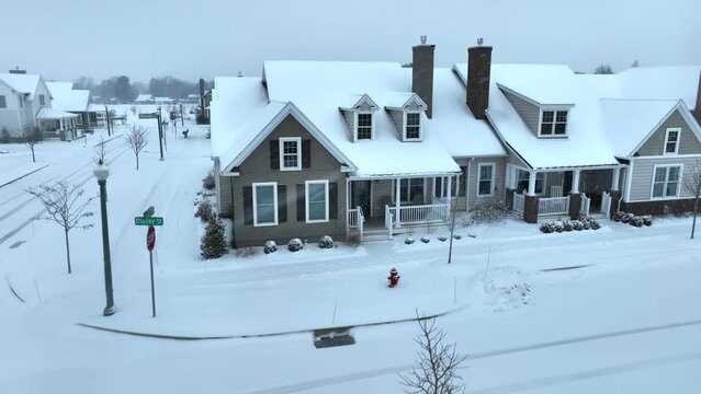 American neighborhood with tightly packed houses. Snow covered homes in winter. Modern retirement community. Aerial push in.