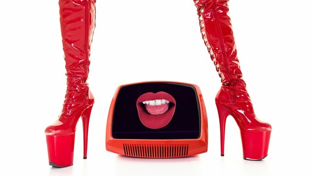 female legs in red high heel stilettos and retro television