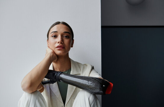 Young woman with black bionic arm at home