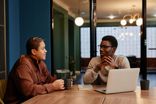Diverse colleagues discussing at conference table in office