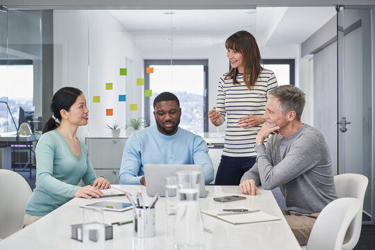 Businesswoman discussing with colleagues in office meeting room