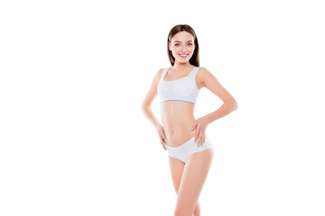 Portrait of thin slender woman with perfect body in white cotton underwear bikini isolated over white background holding hands on waist showing her ideal belly