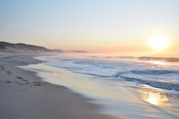 Peaceful misty beach at sunrise with gentle waves