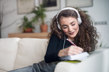 Beautiful woman listening travel podcast, planning summer vacation abroad, going on trip alone. Working on itinerary.