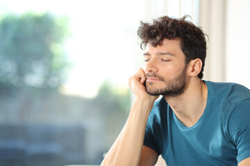 Man relaxing near a window at home