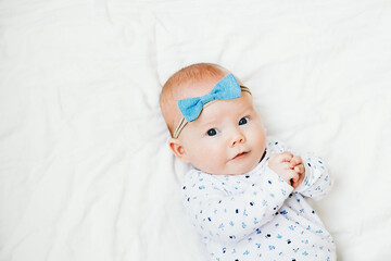 Three month old baby lying on white blanket background
