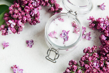 Lilac sugar in glass jar and fresh flowers