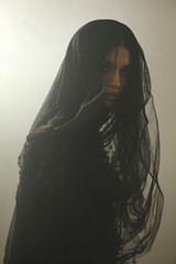 Fashion concept - beautiful Arab woman in a white flying dress in the fog