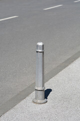 Metal bollard on the sidewalk preventing parking