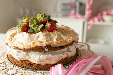 Strawberry cream cake or torte with meringue topping  decorated on kitchen counter