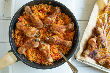 Healthy balkan rice with oven baked chicken drumsticks in a frying pan. Glutenfree dinner or lunch