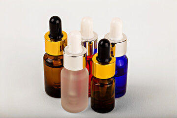 Collection of glass colorful bottles with cosmetic products on white background, emphasizing diversity and luxury in skin care. Essential oils, shampoo, gel, lotion. Natural organic cosmetics