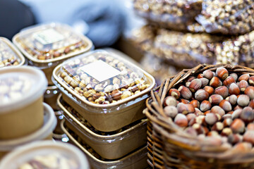Vibrant display of assorted nuts in containers and baskets, showcasing variety of textures and colors, perfect for culinary and healthy lifestyle themes. Selective focus, defocus