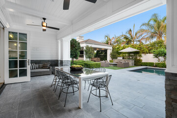 Poolside patio with outdoor dining table in a new construction home in Encino, California - Powered by Adobe
