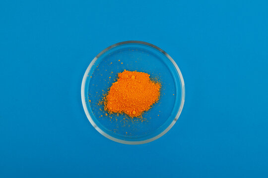 Tartrazine powder in Petri dish, top view. Food coloring, pigment. Food additive E102 used in food, drugs and cosmetics. Tartrazine is synthetic lemon yellow azo dye
