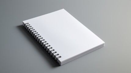 A white spiral notebook rests on a gray surface