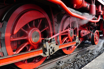 Black and red iron wheels with drive rods of the traditional steam train on the narrow-gauge railroad to Mount Brocken in the Harz Mountains National Park. Wernigerode, Saxony-Anhalt, Germany.