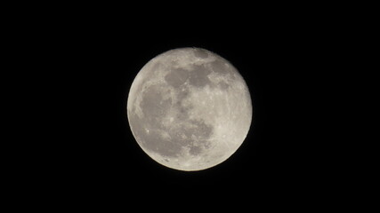 Close-up of a full moon with glowing craters visible
