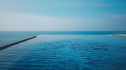 infinity pool merging with ocean horizon under a blue sky