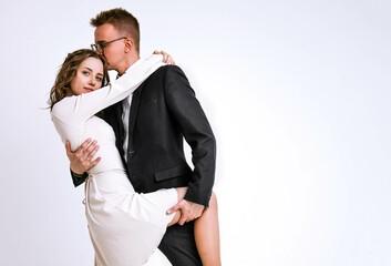 Cute newlyweds on a white background. Couple in love. Family and love concept. A guy in a black...