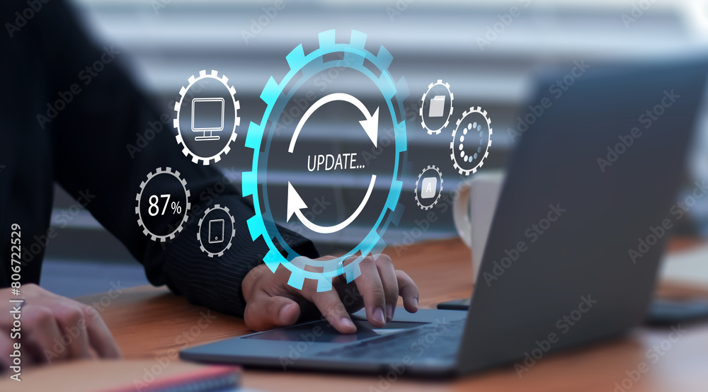 Fototapete Businessman updating computer system for device operating system to be up to date with new version. Graphics icon showing updating function screen loading on computer laptop.