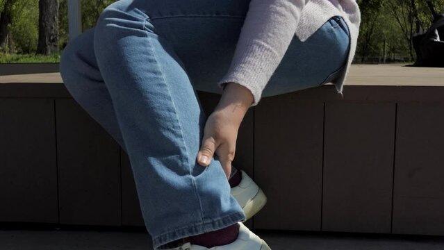 A woman strokes the bottom of her leg