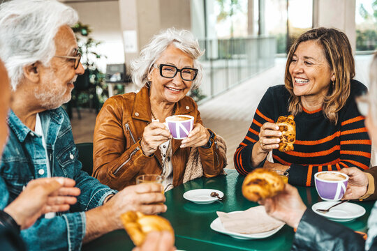Happy senior people having breakfast sitting at cafe bar - Group of older friends having lunch at restaurant table - Food and beverage life style concept