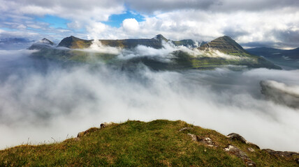 Mountain landscape panorama with ocean. Fog over the Funningur fjord on Eysturoy Island, Faroe Islands.
