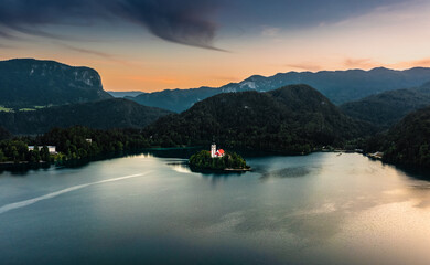Bled, Slovenia - Aerial view of Pilgrimage Church of the Assumption of Maria at Lake Bled (Blejsko Jezero) with Julian Alps at backgroud on a summer afternoon at sunset