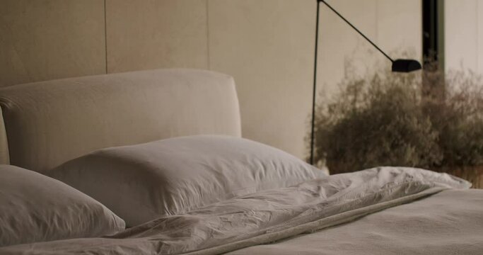 A serene bedroom setting featuring soft pillows on a luxurious bed and a stylish modern lamp, perfect for home decor themes. Elegant Bedroom Interior with Soft Pillows and Modern Lamp