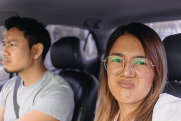 Asian Thai couple traveling by a car, Both unhappy and bored with traffic jam, man is driving on road. 