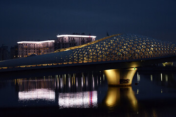 The Atyrau Bridge in the capital of Kazakhstan, Astana, connects the right and left banks of the Ishim (Yesil) River. The bridge is pedestrian, unusually and beautifully illuminated, modern, art, buil