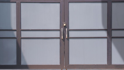 Black and gray aluminium gate door background in minimal style with sunlight and shadow on surface