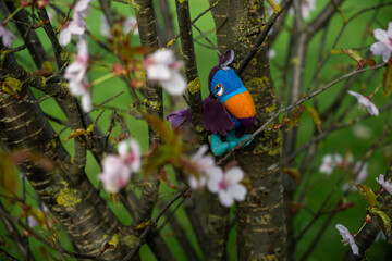 cute soft toy among the branches of cherry blossoms