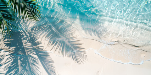 Bright and sunny beach scene from above displaying inviting palm shadows on the sand, evoking holiday vibe