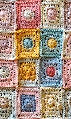 A crocheted blanket with many different colors.