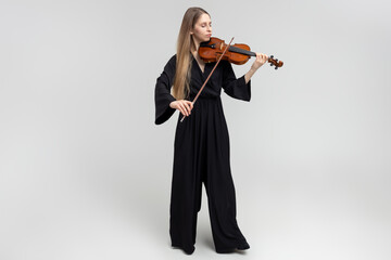 Full length portrait of attractive woman musician playing violin