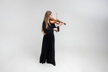Beautiful young woman playing violin © zinkevych