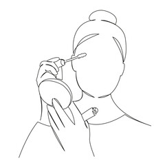 woman applying mascara to her eyes