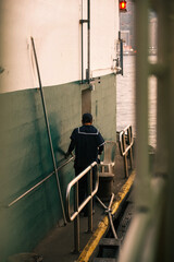 Harbor Labor: Man Working at the Pier, View from Behind