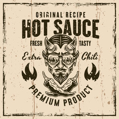 Hot sauce vector emblem, badge, label or prints with devil head and crossed chili peppers. Illustration on background with grunge textures and frame