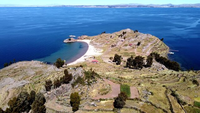 Aerial footage of Taquile Beach and terraced fields on Taquile island in Titicaca Lake, Peru