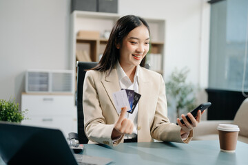 Woman using smart phone for mobile payments online shopping, omni channel, sitting on table