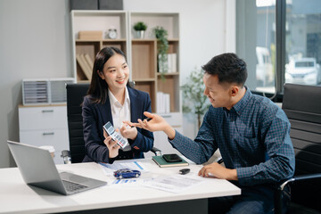 Asian people car salesman or sales manager offers to sell a car and explains of signing a car contract